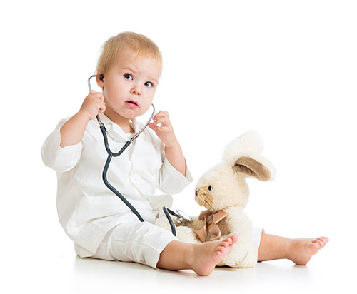 Adorable child with clothes of doctor examining hare toy over wh